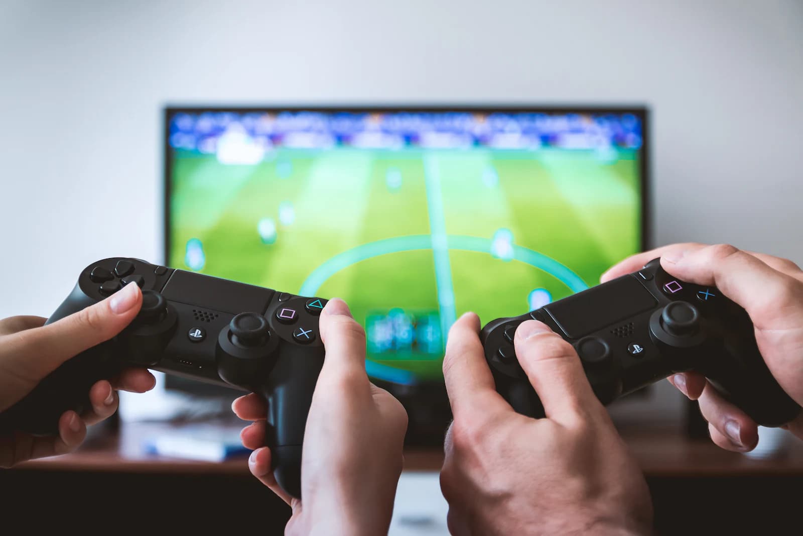 Two people holding game controllers in front of a TV
