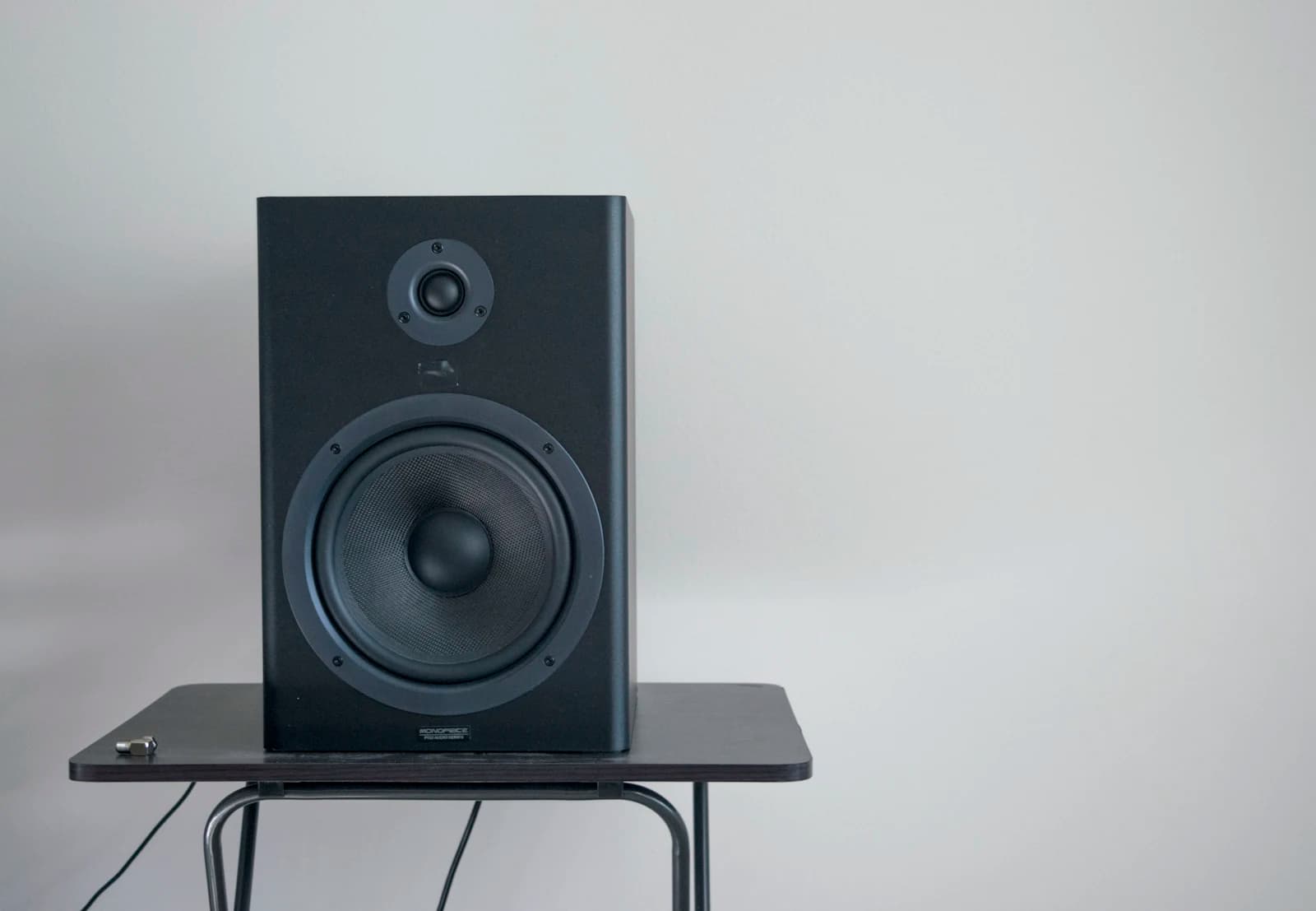 Black studio monitor speaker on a small table